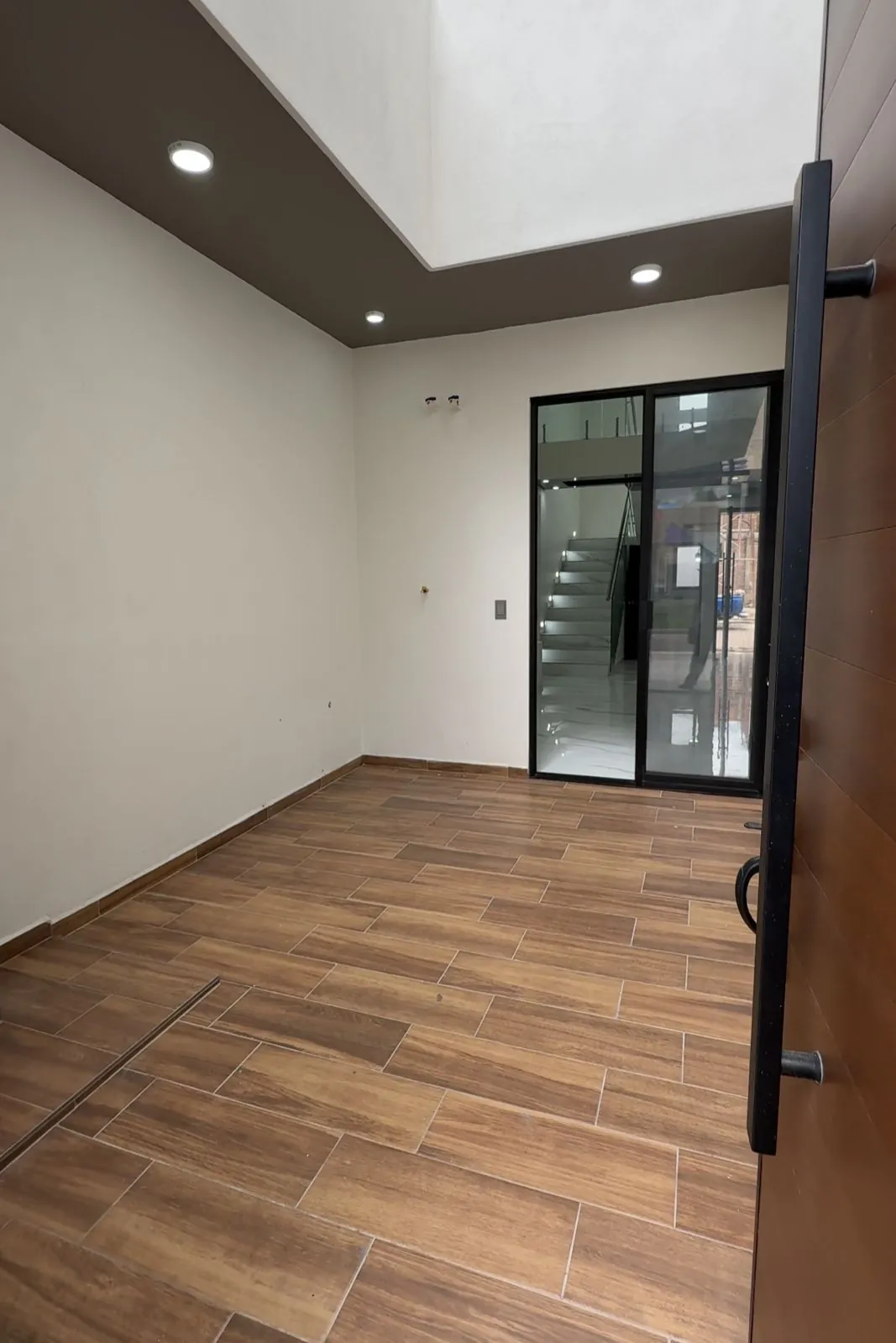 Puerta principal de madera y vestíbulo con piso tipo madera, Santa Bárbara Residencial